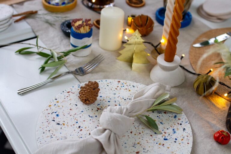 Amble Terrazzo Jesmonite placemats with linen napkins and christmas decorations on table.