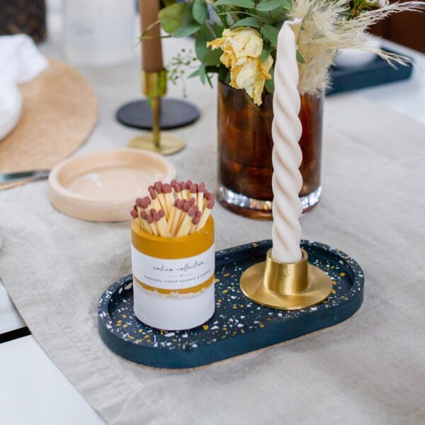 Mustard striker pot on navy tray with candle holder & twist candle.