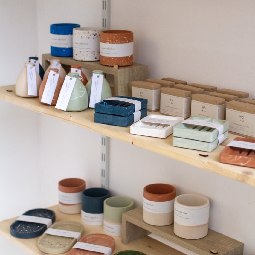 Calico Collective products on shelves in pop up shop in terracotta, blue, green and white.