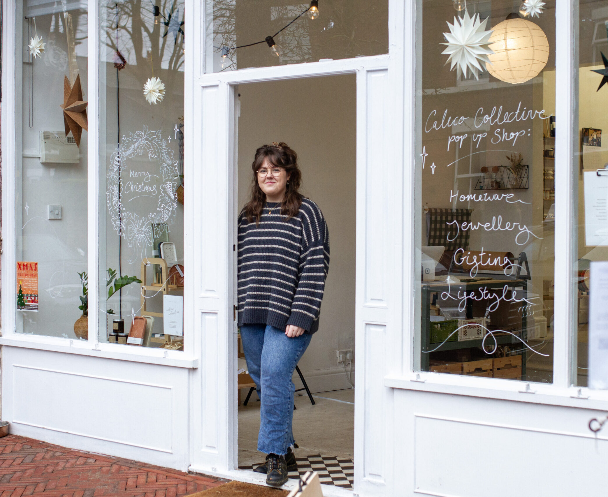 Founder of Calico Collective, Charlotte, stood in the doorway of a pop up shop at Christmas.