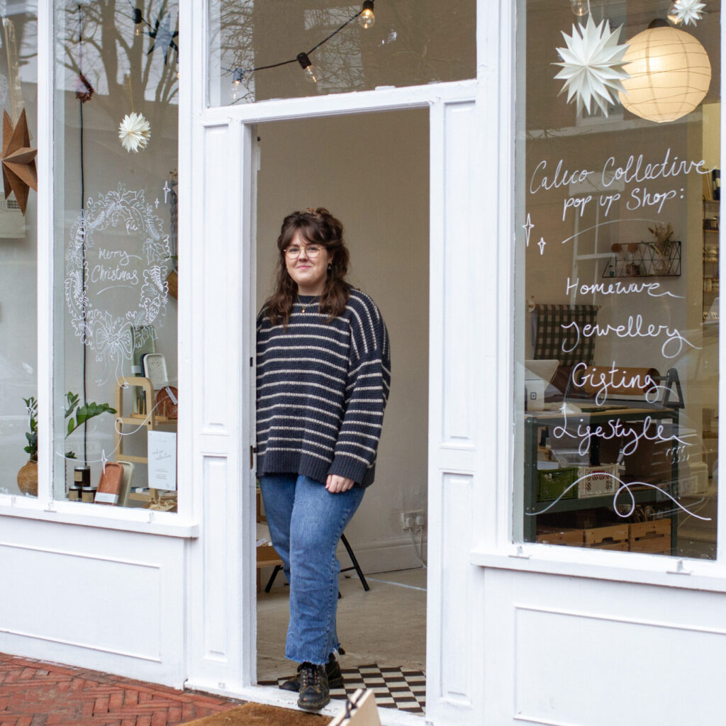 Calico Collective founder Charlotte Dearman in striped jumper outside pop up shop