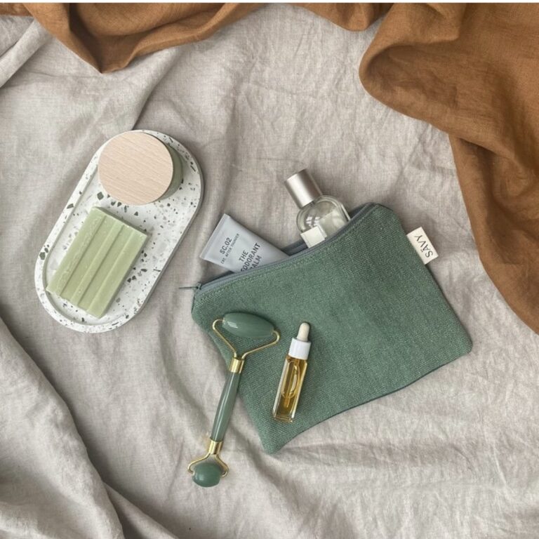 Flat lay image with Calico Collective white terrazzo tray, a linen makeup bag and accessories.