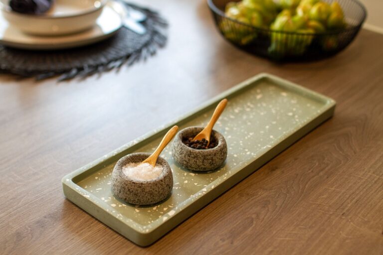 Green and white terrazzo display tray with salt & pepper pinch pots and wooden table.