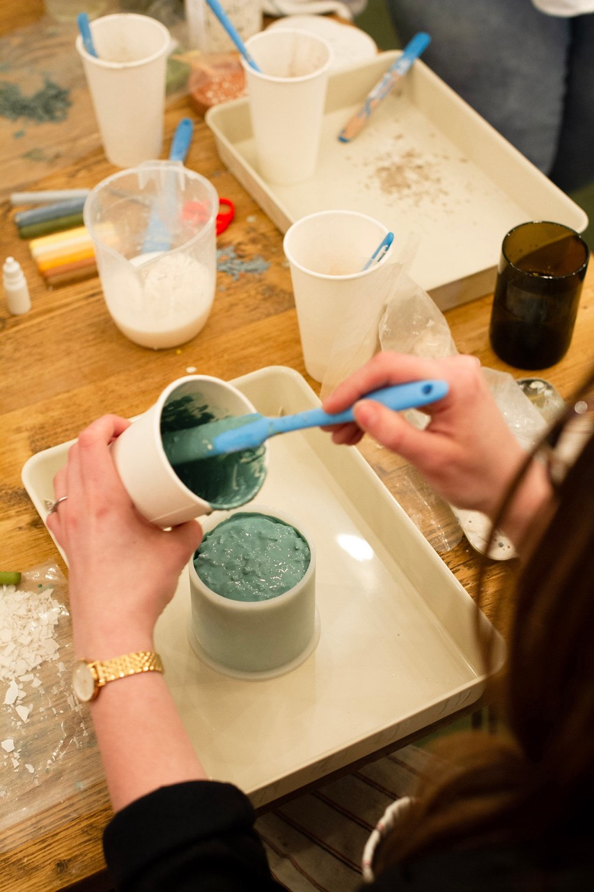 Pouring blue jesmonite into a plant pot mould.