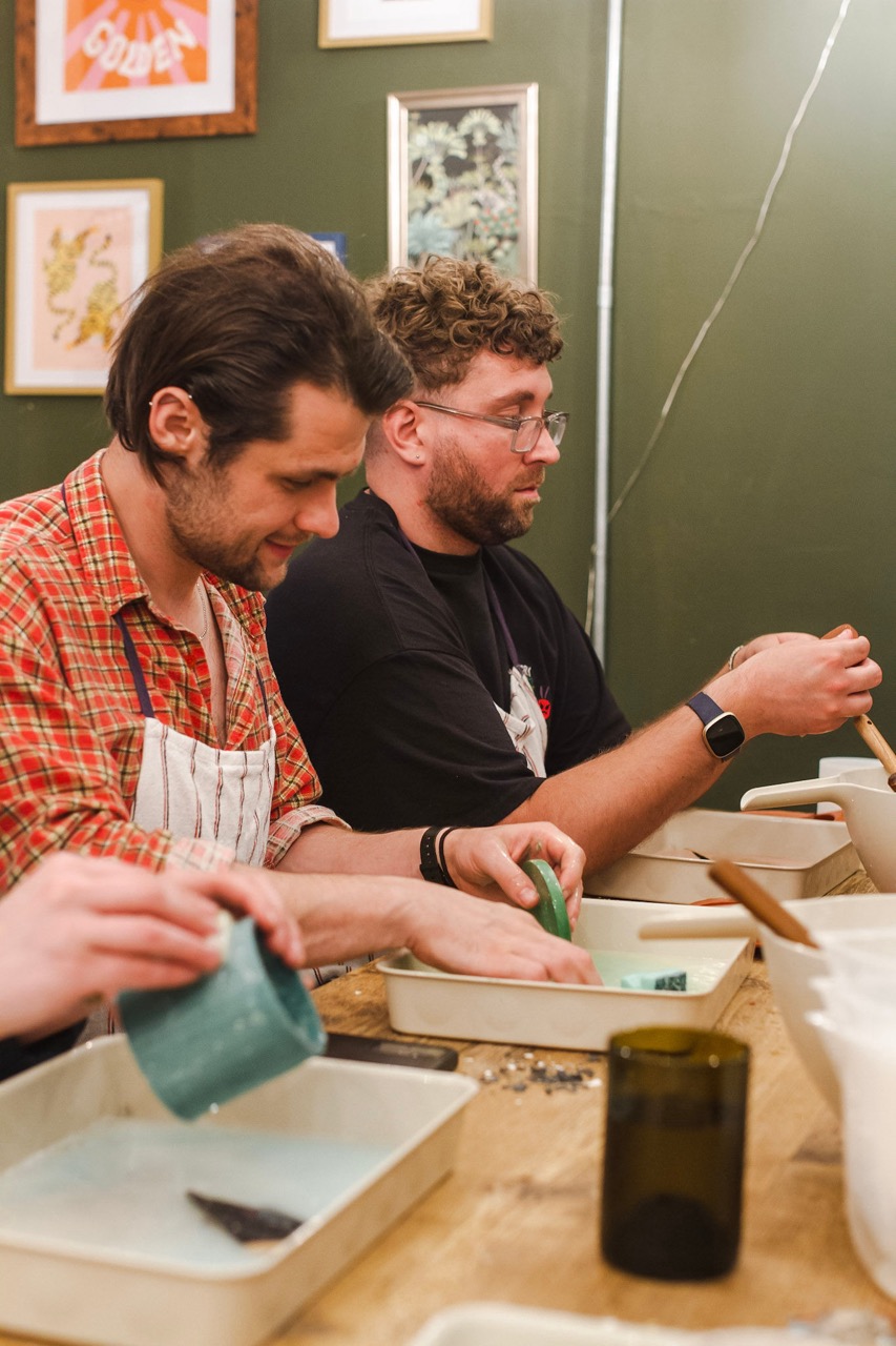 Workshop participants sanding terrazzo pots