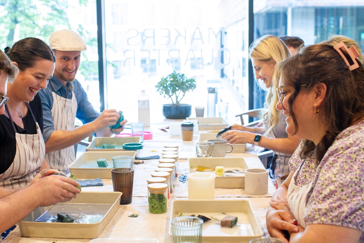 Workshop participants sanding terrazzo homeware at a big table